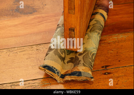 Un doppio dispositivo paraspifferi scorre con la porta di legno come si apre e si chiude Foto Stock