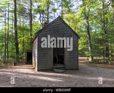 Replica di Henry David Thoreau's little one-camera cabina nei boschi, con camino e legnaia, a Walden Pond in autunno. Concord, MA. Foto Stock