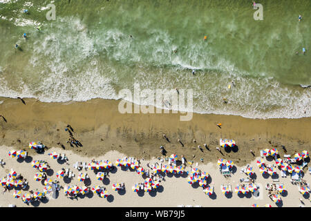 Agosto 24, 2019, San Diego, California, U.S: Ombrelli la linea di costa come frequentatori di spiaggia wade in acque dell'Oceano Pacifico a La Jolla Shores Beach a San Diego in una calda giornata estiva. (Credito Immagine: © KC Alfred/ZUMA filo) Foto Stock