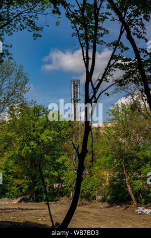 Fumo camino industriale contro il cielo blu con nuvole bianche. Foto Stock