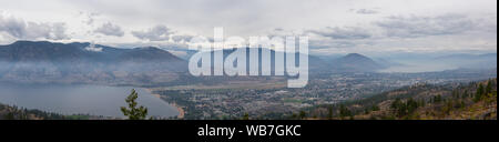 Vista panoramica di Penticton Città durante una torbida e smokey mattina d'estate. Prese a Skaha Bluffs Parco Provinciale, British Columbia, Canada. Foto Stock