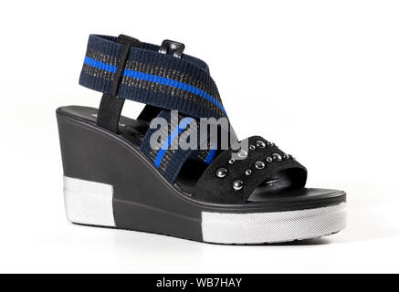 Femmina con tacco alto zeppa sandalo scarpa con decorativa fascia elastica con tomaie in nero e blu su uno sfondo bianco con spazio di copia Foto Stock