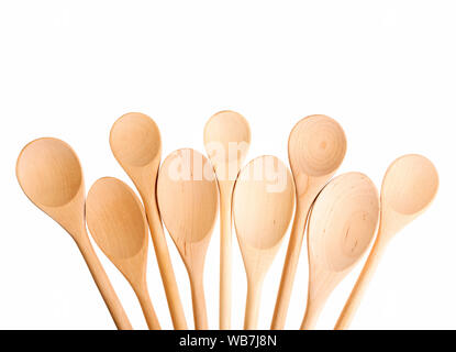 Cucchiai vuoti di dimensioni differenti isolati. Tanti cucchiai di legno su sfondo bianco per il testo. Foto Stock