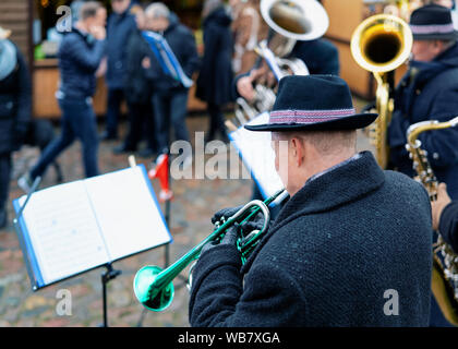 Uomo in orchestra che suona la tromba a Mercatino di Natale nel quartiere di Charlottenburg di Berlino in Germania in inverno. Prestazioni della persona con strumenti musicali Foto Stock