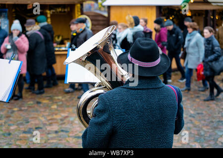 Uomo in orchestra che suona la tromba sul mercato di Natale nel quartiere di Charlottenburg di Berlino in Germania in inverno. Prestazioni della persona con strumenti musicali Foto Stock