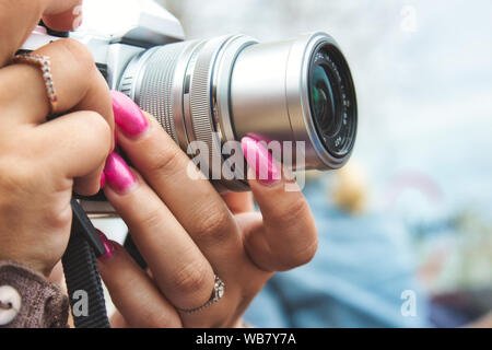 Close-up di una fotocamera digitale utilizzata da una donna con le unghie verniciate Foto Stock