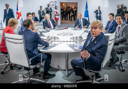 Biarritz, Francia. 24 Agosto, 2019il Cancelliere tedesco Angela Merkel (CDU) si siede accanto al Presidente americano Donald Trump (terzo da destra), il presidente francese Emanuel Macron (secondo da sinistra), mentre il Canada il Primo Ministro Justin Trudeau, Boris Johnson, Primo ministro della Gran Bretagna, il Consiglio UE presidente Donald Tusk, attuale Primo Ministro dell'Italia, Giuseppe Conte e il Giappone il Primo Ministro Shinzo Abe sedersi alla prima sessione di lavoro del Vertice G7. Il vertice del G7 si terrà dal 24 al 26 agosto a Biarritz. Foto: Michael Kappeler/dpa Credito: dpa picture alliance/Alamy Live News Credito: dpa picture al Foto Stock