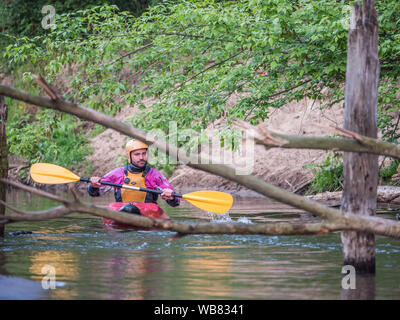 Józefów, Polonia - 12 Maggio: canoa, kayak estreme. Il ragazzo in un piccolo sport kayak overcomuing è un difficile ostacolo sul fiume Swider in Polan Foto Stock