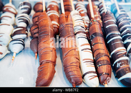 Banana smaltati in cioccolato nel mercato di Natale in Germania in Europa in inverno. Il tedesco strada notte Xmas e fiera vacanze in città europea o in città, Dec Foto Stock