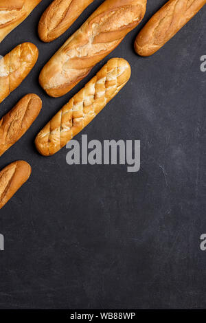 Il pane è righe a sfondo nero. Concetto di banner per il testo con gustoso pane Foto Stock