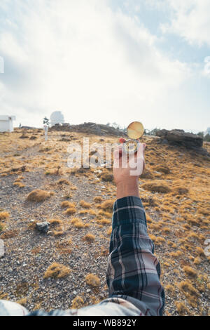 Donna di mano che tiene una bussola con una montagna in background Foto Stock