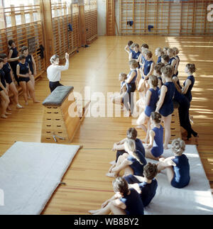 Scuola ginnastica negli anni sessanta. Un insegnante in una scuola palestra si tiene una lezione e gli studenti sono in ascolto alle sue istruzioni. La Svezia degli anni sessanta Foto Stock