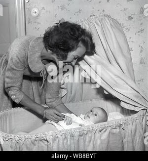 La maternità negli anni cinquanta. Una madre è cuddling con il suo bambino a casa. La Svezia 1955. Kristoffersson ref BT40-4 Foto Stock