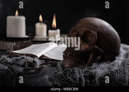 Scary teschio umano con candele accese in background il concetto di Halloween Foto Stock