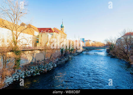 Franziskanerkirche, o chiesa francescana e il fiume Mur nel centro cittadino e la vecchia città di Graz in Austria. Città in Stiria in Europa. Viaggi e storia. Foto Stock