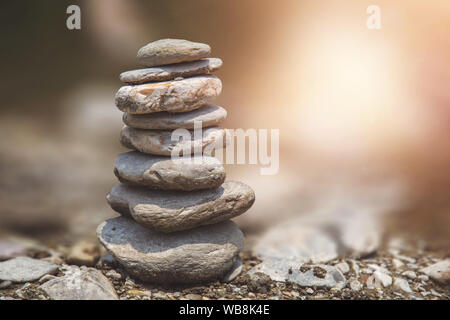 Pietre di fiume equilibrato sulla roccia. Piramide di pietre di fiume su di un altro Foto Stock