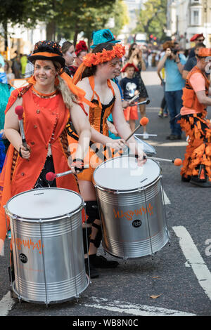 Notting Hill,UK,25 agosto 2019,il carnevale di Notting Hill l'Europa è il più grande festival di strada con musica, balli, parata e cibo. I bambini nei loro costumi sgargianti sfilano lungo il percorso a ballare la musica e bande di acciaio. Il glorioso sole aggiunge alla festa dell'umore. Oltre 12.000 ufficiali di polizia sono sul dovere di aiutare con controllo della folla e a prevenire la criminalità.Credit: Keith Larby/Alamy Live News Foto Stock