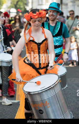 Notting Hill,UK,25 agosto 2019,il carnevale di Notting Hill l'Europa è il più grande festival di strada con musica, balli, parata e cibo. I bambini nei loro costumi sgargianti sfilano lungo il percorso a ballare la musica e bande di acciaio. Il glorioso sole aggiunge alla festa dell'umore. Oltre 12.000 ufficiali di polizia sono sul dovere di aiutare con controllo della folla e a prevenire la criminalità.Credit: Keith Larby/Alamy Live News Foto Stock