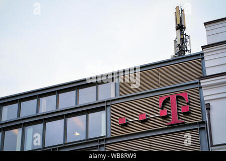 Berlino, Germania - 12 dicembre 2017: vetro moderno European business edilizia architettura con logo T operatore di telefonia mobile in tedesco nel centro di Berlino in Germania d'Europa. Foto Stock