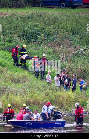 24 agosto 2019, Sassonia, Bad Schandau: durante il 'Schöna 2019' membro disaster esercizio di controllo, gli operatori di soccorso il trasporto persone ferite alle rive del fiume Elba e portarli su barche. Dopo una tempesta che dura per giorni oltre la Svizzera Sassone e intorno a Dresda la catastrofe succede: una frana seppellisce le tracce nella stretta valle dell'Elba non lontano dal confine della Repubblica ceca. Un treno Eurocity delle unità nel ghiaione valanga e ha un incidente. Questo scenario in un terreno quasi impraticabile è stato il punto di partenza per la Sassonia la più grande catastrofe esercizio di controllo per data. Foto: Daniel Schäfer/dpa-Zent Foto Stock