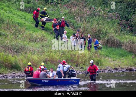 24 agosto 2019, Sassonia, Bad Schandau: durante il 'Schöna 2019' membro disaster esercizio di controllo, gli operatori di soccorso il trasporto persone ferite alle rive del fiume Elba e portarli su barche. Dopo una tempesta che dura per giorni oltre la Svizzera Sassone e intorno a Dresda la catastrofe succede: una frana seppellisce le tracce nella stretta valle dell'Elba non lontano dal confine della Repubblica ceca. Un treno Eurocity delle unità nel ghiaione valanga e ha un incidente. Questo scenario in un terreno quasi impraticabile è stato il punto di partenza per la Sassonia la più grande catastrofe esercizio di controllo per data. Foto: Daniel Schäfer/dpa-Zent Foto Stock