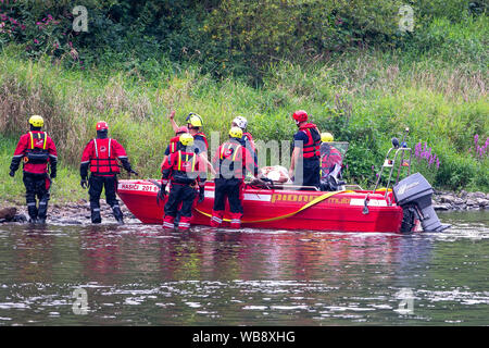 24 agosto 2019, Sassonia, Bad Schandau: durante il 'Schöna 2019' membro disaster esercizio di controllo, gli operatori di soccorso il trasporto persone ferite alle rive del fiume Elba e portarli su barche. Dopo una tempesta che dura per giorni oltre la Svizzera Sassone e intorno a Dresda la catastrofe succede: una frana seppellisce le tracce nella stretta valle dell'Elba non lontano dal confine della Repubblica ceca. Un treno Eurocity delle unità nel ghiaione valanga e ha un incidente. Questo scenario in un terreno quasi impraticabile è stato il punto di partenza per la Sassonia la più grande catastrofe esercizio di controllo per data. Foto: Daniel Schäfer/dpa-Zent Foto Stock