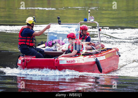 24 agosto 2019, Sassonia, Bad Schandau: persone ferite sono prese di distanza in barca da forze di soccorso durante il 'Schöna 2019' disastro nazionale esercizio di controllo. Dopo una tempesta che dura per giorni oltre la Svizzera Sassone e intorno a Dresda la catastrofe succede: una frana seppellisce le tracce nella stretta valle dell'Elba non lontano dal confine della Repubblica ceca. Un treno Eurocity delle unità nel ghiaione valanga e ha un incidente. Questo scenario in un terreno quasi impraticabile è stato il punto di partenza per la Sassonia la più grande catastrofe esercizio di controllo per data. Foto: Daniel Schäfer/dpa-Zentralbild/ZB Foto Stock