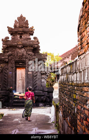 Donna Balinese che trasportano offerta a Dio. Offrendo fiori a Dio la cultura Balinese. Foto Stock