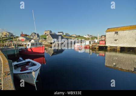 Ampio angolo di visione di barche e baracche di pesca con riflessioni a ora d'oro,scenic Peggy's Cove,Nova Scotia, Canada Foto Stock