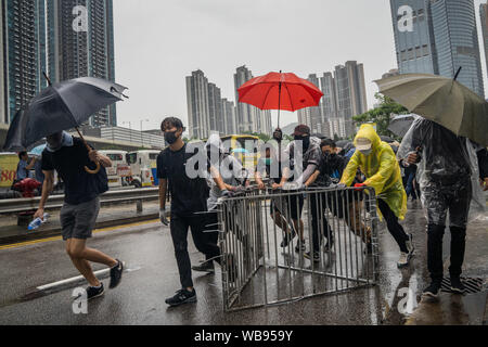 I dimostranti utilizzare barriere di metallo per costruire il blocco stradale in quanto occupano una strada durante la dimostrazione.decine di migliaia di pro-democrazia manifestanti hanno aderito per le strade di Hong Kong in un altro round di dimostrazione innescato dall'ora sospesa estradizione disegno di legge presentato dal governo. Tuttavia i dimostranti chiedono un ritiro totale del conto e la richiesta del governo di istituire un organismo indipendente di indagare sulla polizia brutalità azioni contro i dimostranti. Foto Stock