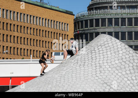 Arrampicata per bambini su Amos Rex art museum lucernario - altri edifici riconoscibili in background - a Helsinki in Finlandia Foto Stock