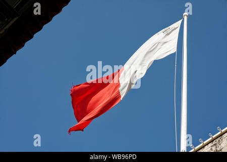 Bandiera di Malta battenti; bianco; rosso; Giorgio Croce; simbolo Maltese; Cavalieri Ospitalieri di San Giovanni; 2 angoli strappati, cielo blu; Europa; Balzan; Malta; sp Foto Stock