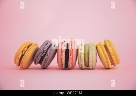 Lineup di un assortimento di amaretti francese su sfondo rosa Foto Stock