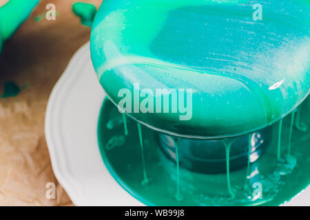 Mousse di torta di yogurt. Ragazze cook e creano un disegno di mousse sulla torta. Specchio congelati ciliegina sulla torta. Capolavori culinari Foto Stock