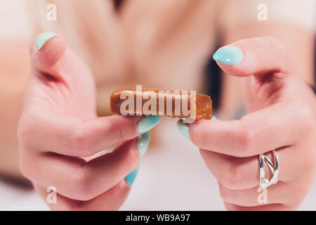 Fatto a mano caramello toffee pezzi con sale marino su cucina pietra sullo sfondo della piastra Foto Stock