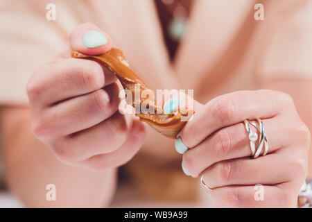 Fatto a mano caramello toffee pezzi con sale marino su cucina pietra sullo sfondo della piastra Foto Stock