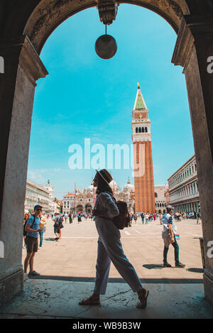 Donna di fronte del campanile di San Marco a Venezia Italia Foto Stock