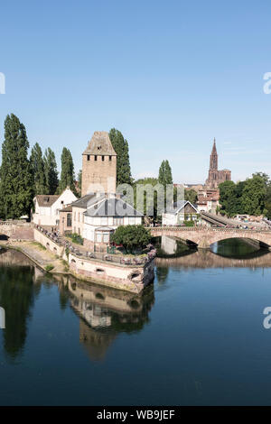 Una vista in alzata di una delle torri del Barrage Vauban sul fiume Ill, con la cattedrale in background, a Strasburgo, Francia. Foto Stock