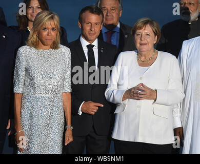 Brigitte Macron, presidente francese Emmanuel Macron, e il Cancelliere tedesco Angela Merkel unirsi ad altri leader politici di tutto il mondo per la foto di famiglia al Vertice del G7 a Biarritz, Francia. Foto Stock