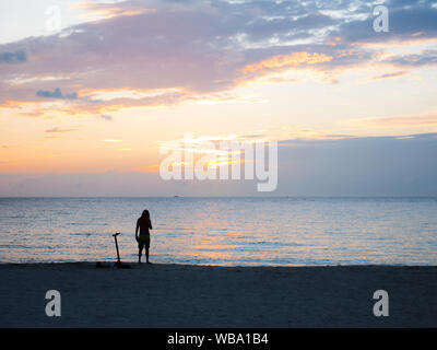 Un uomo è in piedi da soli, contempling il bellissimo tramonto a Miami Beach, Florida, Stati Uniti d'America Foto Stock