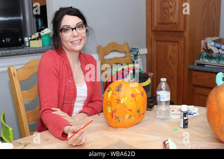 Insegnante che mostra gli studenti di pittura di zucca. Foto Stock