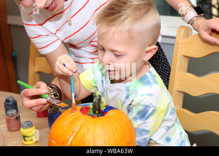 Insegnante che mostra gli studenti di pittura di zucca. Foto Stock