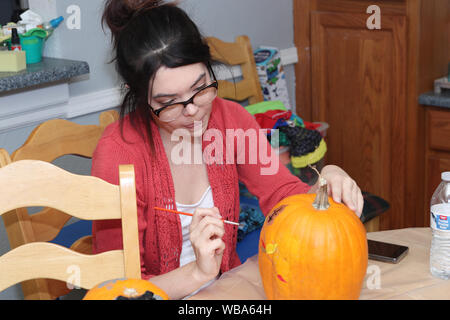 Insegnante che mostra gli studenti di pittura di zucca. Foto Stock