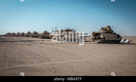 190818-M-ET529-1034 CAMP BUEHRING, KUWAIT (Agosto 18, 2019) Marines assegnato all India Company, Battaglione Team di atterraggio 3/5, undicesimo Marine Expeditionary Unit (MEU), e soldati assegnato al primo battaglione (MECHANIZED), 8° Reggimento di Fanteria, prepararsi ad incendi M1A1 Abrams pistola principale ed un M2 Bradley veicolo di combattimento. Il Boxer anfibio gruppo pronto e undicesimo MEU sono distribuiti negli Stati Uniti Quinta Flotta area di operazioni a sostegno di operazioni navali per garantire stabilità marittimo e la sicurezza nella regione centrale di collegamento del Mediterraneo e del Pacifico attraverso l'Oceano Indiano occidentale e tre strateg Foto Stock