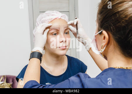 Cosmetologo preparando per trucco permanente, di tatuaggio delle sopracciglia. Nel salone di bellezza Foto Stock