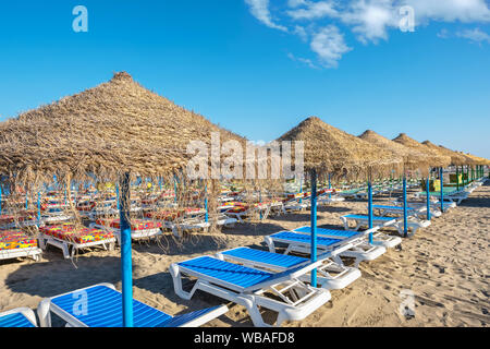 Sedie a sdraio e ombrelloni di paglia sulla spiaggia di Carihuela. Torremolinos Costa del Sol, Andalusia, Spagna Foto Stock