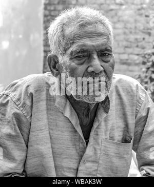 Foto in bianco e nero di antiquata Senior Citizen nei suoi primi anni ottanta, con le rughe sul viso e sul collo, pensare profondamente & posa con espressione cupa Foto Stock