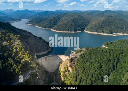 Antenna vista superiore su una montagna Fagaras e la diga di Vidraru con un serbatoio di lago, costruito sul fiume di Arges e si trova su una strada Transfagarashian, Romani Foto Stock