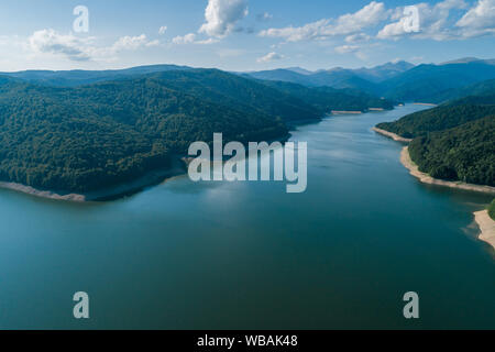Antenna vista superiore su una montagna Fagaras Vidraru circostante diga con un serbatoio Lago, costruito sul fiume di Arges e si trova su una strada Transfagarasan, Foto Stock