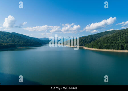 Antenna vista superiore su una montagna Fagaras Vidraru circostante diga con un serbatoio Lago, costruito sul fiume di Arges e si trova su una strada Transfagarasan, Foto Stock